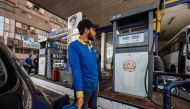 A worker fills the tank of a vehicle at a petrol station in Cairo on March 2, 2023 as Egypt's government announced a new increase in fuel prices. (Photo by Khaled Desouki / AFP)