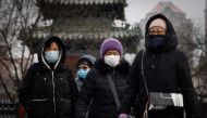 People wear face masks as they walk on a snowy morning as the coronavirus disease (COVID-19) continues in Beijing, China, January 20, 2022. (REUTERS/Thomas Peter)