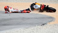 Honda Spanish rider Marc Marquez falls after crashing with Aprilia Portuguese rider Miguel Oliveira (out of frame) during the MotoGP race of the Portuguese Grand Prix at the Algarve International Circuit in Portimao, on March 26, 2023. Photo by PATRICIA DE MELO MOREIRA / AFP