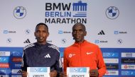 Kenya's world record holder Eliud Kipchoge (R) and Kenya's Amos Kipruto pose with their bib at a press conference on September 22, 2023 in Berlin. (Photo by Odd ANDERSEN / AFP)