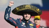 Verstappen celebrates on the podium after winning the race. AFP