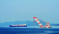 A large liquefied natural gas (LNG) carrier and a floating crane anchor in the harbour near Samsung Heavy Industries in Geoje island, South Korea.