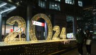 People walk past a light installation for the upcoming new year in Beijing on December 27, 2023. (Photo by JADE GAO / AFP)
