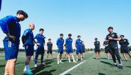 Japan coach Hajime Moriyasu speaks to his players during a training session.