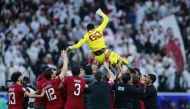 Qatar's players and officials toss goalkeeper Meshaal Barsham in the air after the victory at Al Bayt Stadium, yesterday.