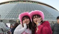 Fans of US singer Taylor Swift, also known as Swifties, pose for photos outside the Tokyo Dome shortly before the start of the first leg of her Asia-Pacific 