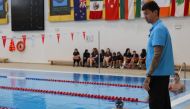 Doha 2024 ambassador Anthony Ervin speaks with young swimmers. 