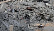 Displaced Palestinians transport their belongings on a horsecart through a street amid the rubble of houses destroyed by Israeli bombardment in Hamad area, west of Khan Yunis in the southern Gaza Strip on March 14, 2024. (Photo by AFP)
