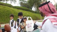 An official distributing Garangao gifts to children on Shakespeare Street in Katara yesterday.