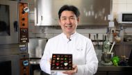 Japanese chocolatier Yasushi Sasaki holds a box of chocolates as he poses for a photograph in his workshop in the Brussels commune of Woluwe-Saint-Pierre on March 14, 2024. (Photo by John Thys / AFP)