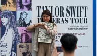 Fans of US singer Taylor Swift, also known as Swifties, take photos as they arrive for the pop star's Eras Tour concert at the National Stadium in Singapore on March 7, 2024. (Photo by Roslan RAHMAN / AFP)

