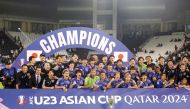 Japan’s players pose for a group picture with the trophy after winning the AFC U23 Asian Cup final against Uzbekistan at Jassim Bin Hamad Stadium in Doha, on Friday. AFP