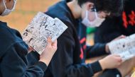 This photo taken on April 13, 2024 shows young players reading the Japanese comic, or manga, 