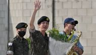 K-pop boy band BTS member Jin (C) waves after being discharged from his mandatory military service next to fellow BTS members RM (R) and Jimin (L) outside a military base in Yeoncheon on June 12, 2024. (Photo by Jung Yeon-je / AFP)