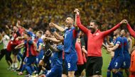 Slovakia's forward #09 Robert Bozenik (centre), staff and teammates celebrate on the pitch after the UEFA Euro 2024 Group E football match between Slovakia and Romania at the Frankfurt Arena in Frankfurt am Main on June 26, 2024. (Photo by Angelos Tzortzinis / AFP)