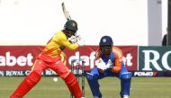 Zimbabwe's Tadiwanashe Marumani (L) plays a shot as India's Sanju Samson (R) looks on during the fourth T20 International cricket match between Zimbabwe and India at Harare Sports Club in Harare on July 13, 2024. (Photo by Jekesai NJIKIZANA / AFP)
