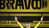 UAE Team Emirates team's Slovenian rider Tadej Pogacar celebrates on the podium with the overall leader's yellow jersey after the 19th stage of the 111th edition of the Tour de France cycling race, 144,6 km between Embrun and Isola 2000, in the French Alps, on July 19, 2024. (Photo by Marco BERTORELLO / AFP)
