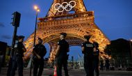 Police officers stand guard near Eiffel Tower in Paris on July 21, 2024, ahead of the Paris 2024 Olympic and Paralympic Games. (Photo by MARTIN BERNETTI / AFP)