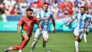 Morocco's forward #10 Ilias Akhomach (L) challenges Argentina's midfielder #07 Kevin Zenon (C) and Argentina's midfielder #10 Thiago Almada in the men's group B football match between Argentina and Morocco during the Paris 2024 Olympic Games at the Geoffroy-Guichard Stadium in Saint-Etienne on July 24, 2024. (Photo by Arnaud FINISTRE / AFP)