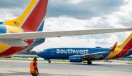 A ramp agent walks past a Southwest Airlines Boeing 737-700 airplane in Baltimore. (Photo by Angus Mordant/Bloomberg)