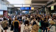 Passengers gather around the departure boards at the Gare Montparnasse train station in Paris on July 26, 2024 as France's high-speed rail network was hit by malicious acts disrupting the transport system hours before the opening ceremony of the Paris 2024 Olympic Games. Photo by Thibaud MORITZ / AFP