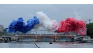 Coloured smoke forms the French flag on the Austerlitz bridge over the river Seine at the start of the opening ceremony of the Paris 2024 Olympic Games in Paris on July 26, 2024. (Photo by Ann Wang / POOL / AFP)