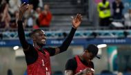 Qatar's #01 Cherif Younousse and Qatar's #02 Ahmed Tijan celebrate a point in the men's pool A beach volleyball match between Italy and Qatar during the Paris 2024 Olympic Games at the Eiffel Tower Stadium in Paris on July 27, 2024. (Photo by Luis TATO / AFP)
