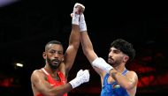 Palestinian Wasim Abusal (in blue) gestures next to Sweden's Nebil Ibrahim at the end of their men's 57kg preliminaries round of 32 boxing match during the Paris 2024 Olympic Games at the North Paris Arena, in Villepinte on July 28, 2024. (Photo by MOHD RASFAN / AFP)
