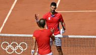 Winner, Serbia's Novak Djokovic (R) shakes hands with Spain's Rafael Nadal (L) after their men's singles second round tennis match on Court Philippe-Chatrier at the Roland-Garros Stadium at the Paris 2024 Olympic Games, in Paris on July 29, 2024. (Photo by Miguel MEDINA / AFP)
