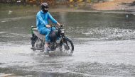 A man ride along a street during rainfall in Karachi on August 1, 2024. (Photo by Asif HASSAN / AFP)
 