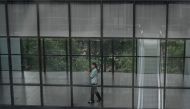 A woman talks on her phone at an office building in Beijing on August 1, 2024. (Photo by JADE GAO / AFP)
