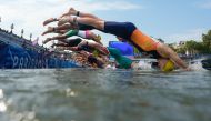 Athletes dive into the Seine river as they start the swimming stage of the men's individual triathlon at the Paris 2024 Olympic Games in central Paris on July 31, 2024. (Photo by David Goldman / POOL / AFP)
