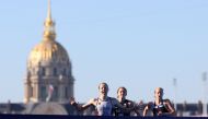 Germany's Laura Lindemann (L) runs to cross the finish in first place followed by Britain's Beth Potter (C) and US' Taylor Knibb, on the Pont Alexandre III at the end of the mixed's relay triathlon race, at the Paris 2024 Olympic Games, in central Paris, on August 5, 2024. (Photo by Franck FIFE / AFP)