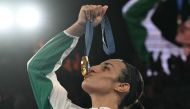 Gold medallist Algeria's Imane Khelif poses on the podium during the medal ceremony for the women's 66kg final boxing category during the Paris 2024 Olympic Games at the Roland-Garros Stadium, in Paris on August 9, 2024. (Photo by MOHD RASFAN / AFP)