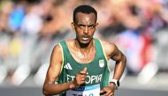 Ethiopia's Tamirat Tola runs on a road from Versailles to Paris in the men's marathon of the athletics event at the Paris 2024 Olympic Games on August 10, 2024. (Photo by Kirill KUDRYAVTSEV / AFP)