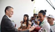 Boxer Imane Khelif (right) is welcomed by Algerian officials.