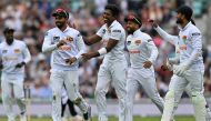 Sri Lanka's Dimuth Karunaratne (L) celebrates with teammates after taking the wicket of England's captain Ollie Pope (unseen) on day two of the thrid cricket test match between England and Sri Lanka on September 7, 2024. (Photo by Glyn KIRK / AFP)