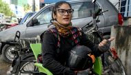 In this photograph taken on August 19, 2024, Amina Sohail, a motorbike rider with a local ride-hailing service provider Bykea, speaks during an interview with AFP in Karachi. (Photo by Rizwan Tabassum / AFP) 