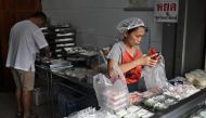 Desserts being packed in single-use plastic containers and bags at a traditional Thai dessert shop in Bangkok. (Photo by Lillian Suwanrumpha / AFP) 