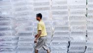 A man walks past plastic bottles on a street in Hanoi on September 16, 2024. (Photo by Nhac NGUYEN / AFP)