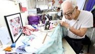 This Photo taken on September 5, 2024 shows Cheongsam master Yan Kar-man working in his small workshop in Kowloon, Hong Kong. (Photo by Peter Parks / AFP) 