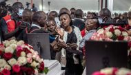 A family member of a deceased student is comforted by relatives and counsellors as she tries to touch a coffin during the memorial service for the 21 Hillside Endarasha Academy school fire victims in Mweiga on September 26, 2024. Photo by LUIS TATO / AFP