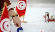 A Tunisian national living in Kuwait dips her finger in ink after casting her vote for the presidential elections at the Tunisian embassy in Kuwait City on October 6, 2024. (Photo by Yasser Al-Zayyat / AFP)