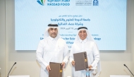 President of UDST Dr. Salem Al Naemi (right) and Chief Executive Officer of Hassad Food Eng. Ali Hilal Al Kuwari exchanging documents after signing an agreement.