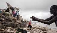 A man repairs his makeshift protection wall, to protect his house before the next high tide arrives in Bargny on September 03, 2020. Photo by JOHN WESSELS / AFP