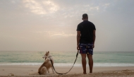 Ahmed brings his dog Rogue, a Siberian husky dog, for a walk at the beach of Nouakchott, on September 28, 2024. Photo by MICHELE CATTANI / AFP