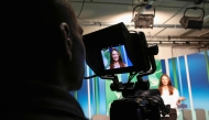 Czech Republic student, 19-year-old Denisa Lacinova is pictured through the monitor of a camera in the media room at the South East Technological University (SETU) in Carlow, eastern Ireland on September 24, 2024, where a new course has started in Content Creation and Social Media. Photo by PAUL FAITH / AFP