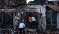 Forensic specialists and emergency responders inspect an area of destroyed houses following a fuel truck explosion in Kigogwa, on October 22, 2024. (Photo by Badru Katumba / AFP)