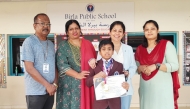 School staff with a student who topped a badminton tournament. 