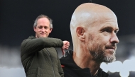 A visitor reacts as he poses in front of a picture of newly sacked Manchester United's Dutch manager Erik Ten Hag, outside Old Trafford, in Manchester, north west England, on October 28, 2024. (Photo by Paul ELLIS / AFP)
